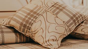 A bed with patterned pillows and a metal headboard.