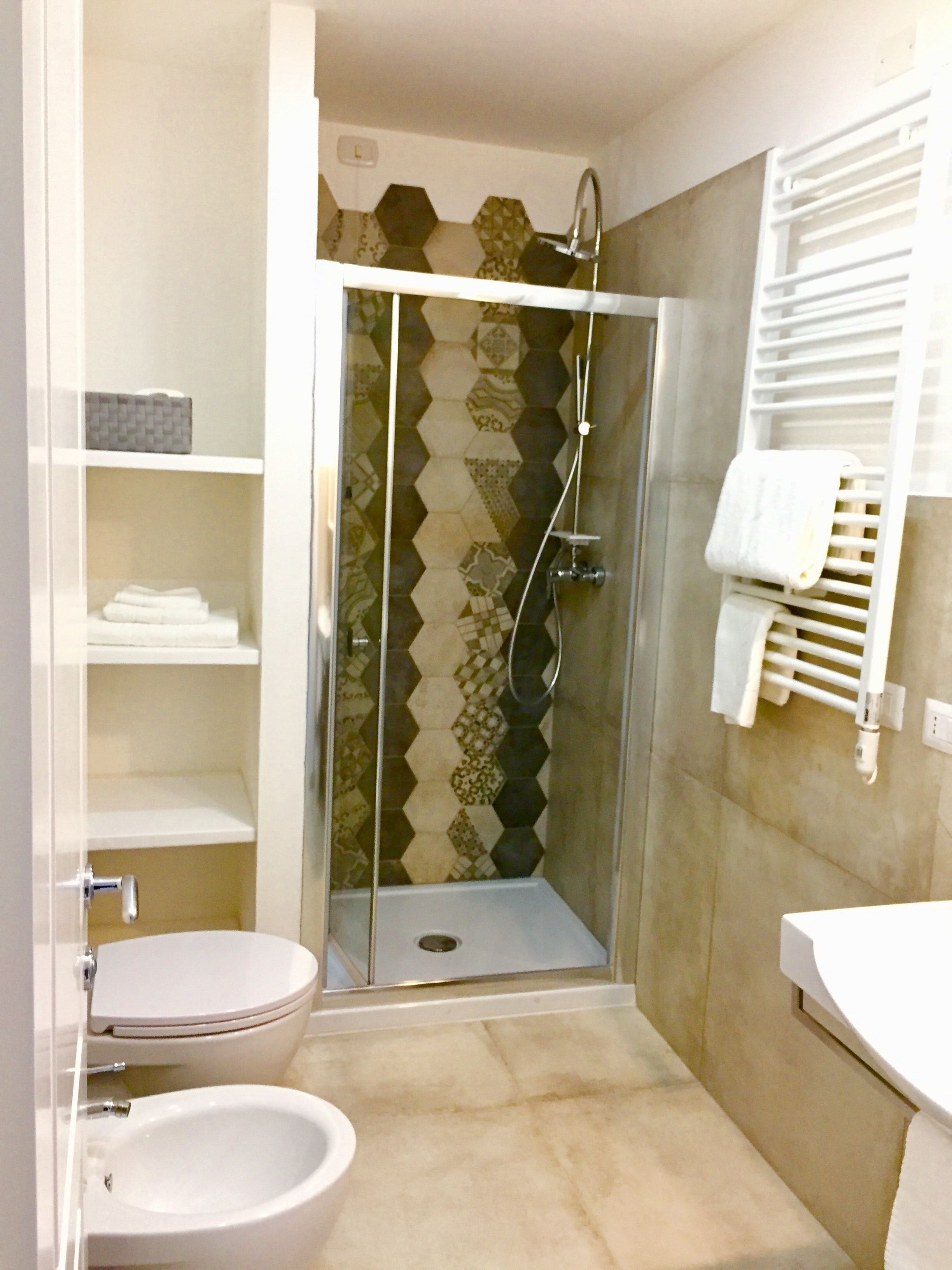 Un baño con cabina de ducha, inodoro y lavamanos.