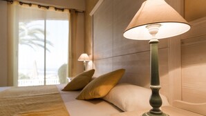 Une chambre d’hôtel avec un lit, deux oreillers, une table de chevet et une lampe.