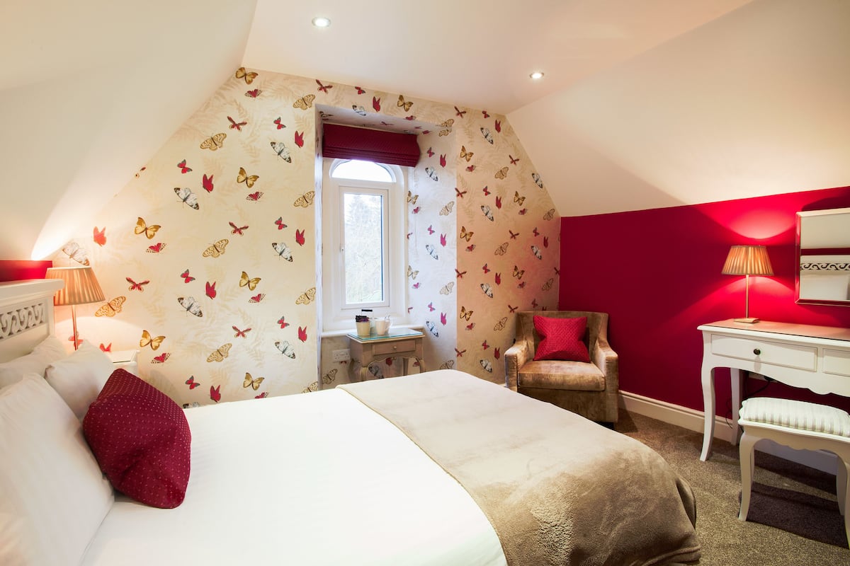 Une chambre à coucher avec un lit, un bureau, une chaise et une fenêtre.