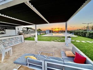 An outdoor patio area with a pool, seating, and a bar. - B&B Tramonti d'aMare (Marsala)