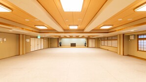 Amplia habitación con techos de paneles de madera, iluminación empotrada y un gran espacio abierto.