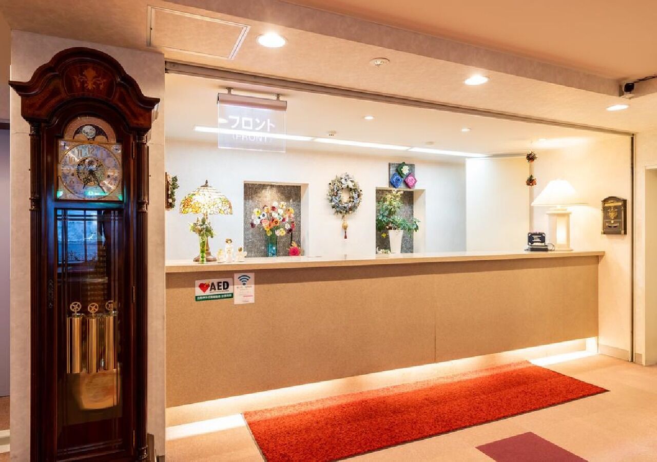 A reception desk with a clock, a sign indicating Wi-Fi availability, and various decorative items.