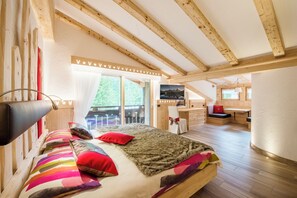 Un dormitorio con cama, escritorio y vistas al exterior.