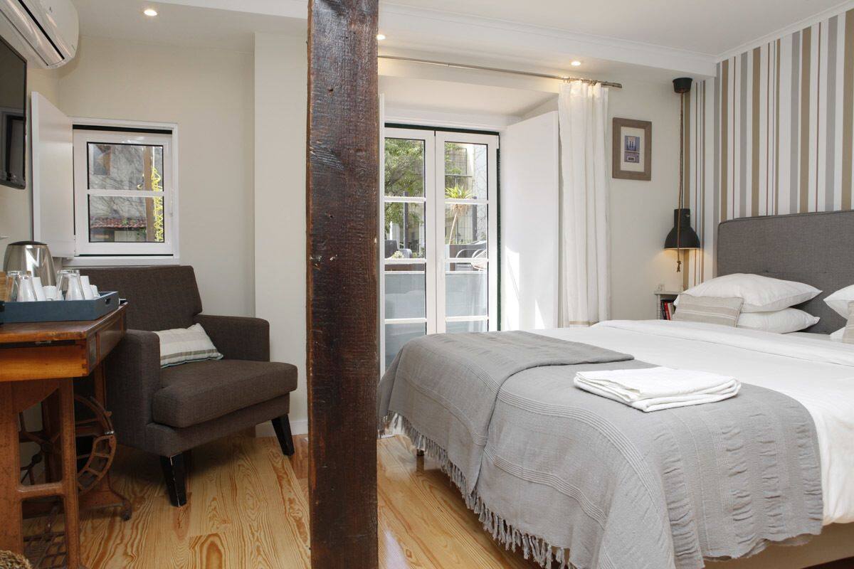 Een hotelkamer met een bed, een stoel, een bureau en een raam.