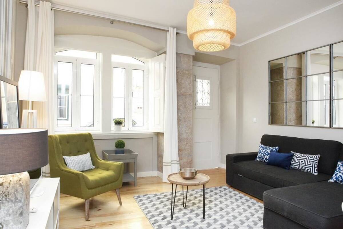Een woonkamer met een bank, fauteuil en een bijzettafeltje met een kom.
