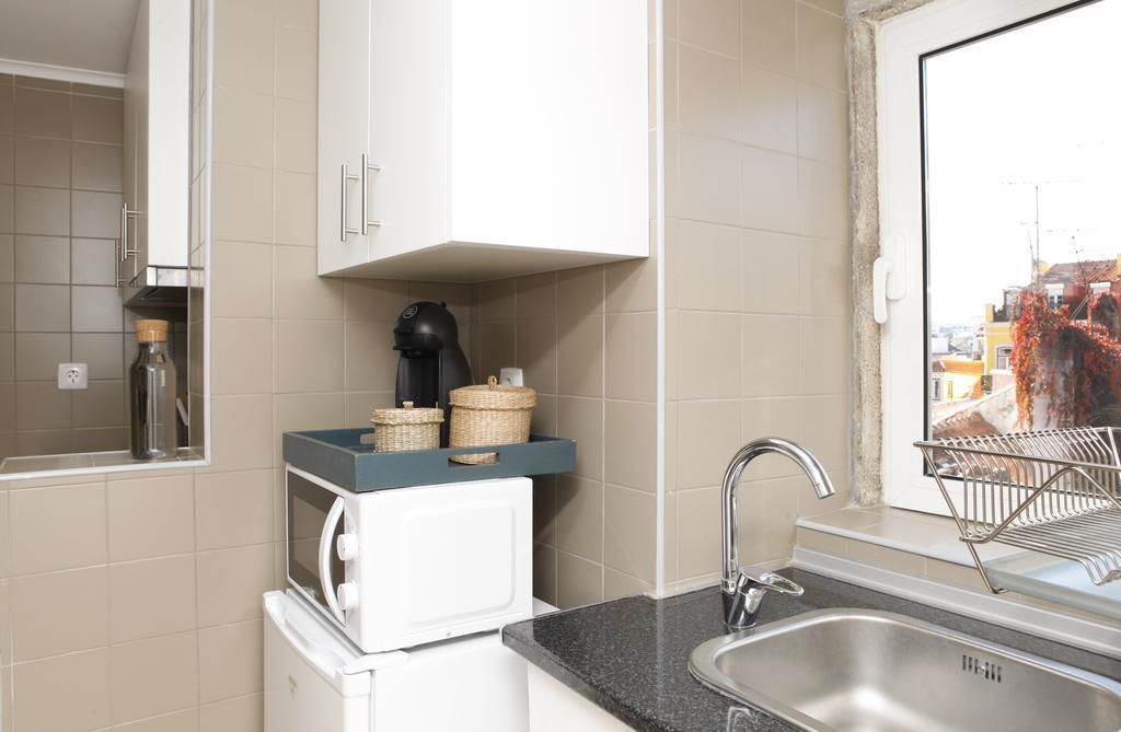 A compact kitchen with a microwave, toaster, and a small sink.
