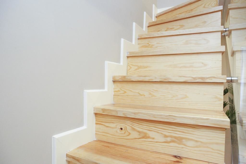 A wooden staircase with a modern design, featuring a series of steps and a handrail.