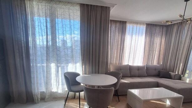 Un salon moderne avec une table ronde, un canapé et une table basse.