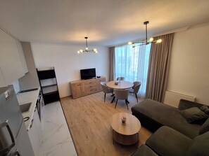 Suíte família, várias camas, vista para a cidade | Área de estar | TV de tela plana