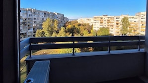 Un balcon donnant sur des immeubles et des arbres.