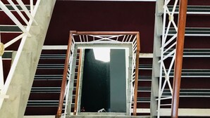 Una escalera de caracol con barandales blancos y pasamanos de madera, que conduce a una zona de desembarco oscura.