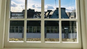 Una ventana con vistas a edificios y un cielo despejado.