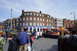 Ein belebter Markt im Freien mit verschiedenen Ständen und Einkäufern.