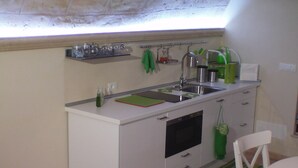 A compact kitchen with a built-in oven, a sink, and a small countertop. - B&B La Grotta (Mesagne)