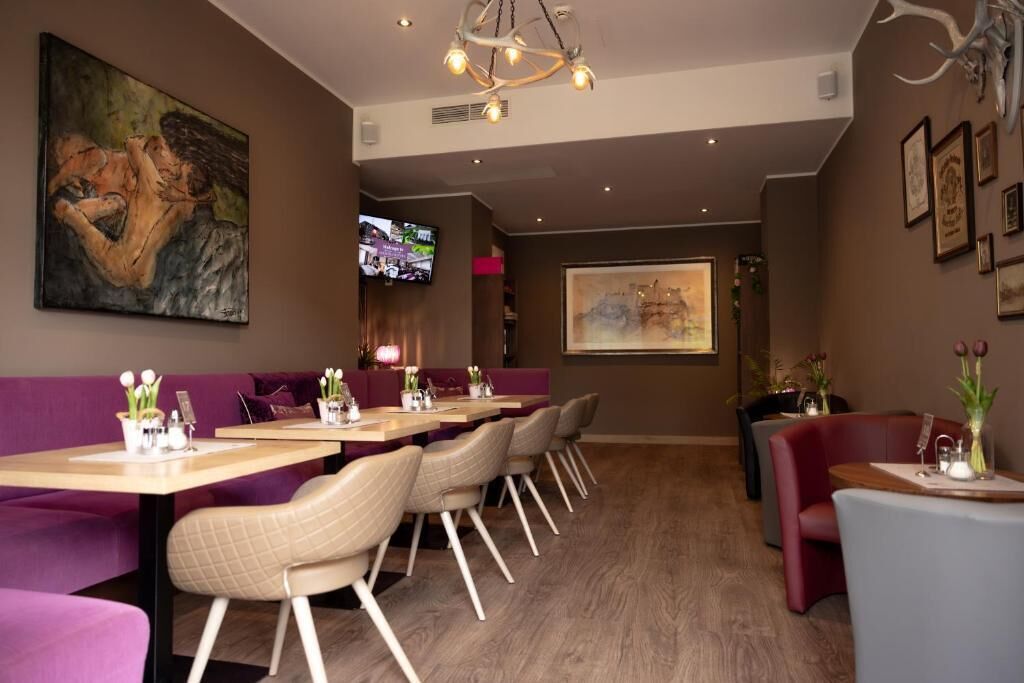 Un restaurant doté d’un long comptoir, de sièges confortables et d’un écran de télévision.