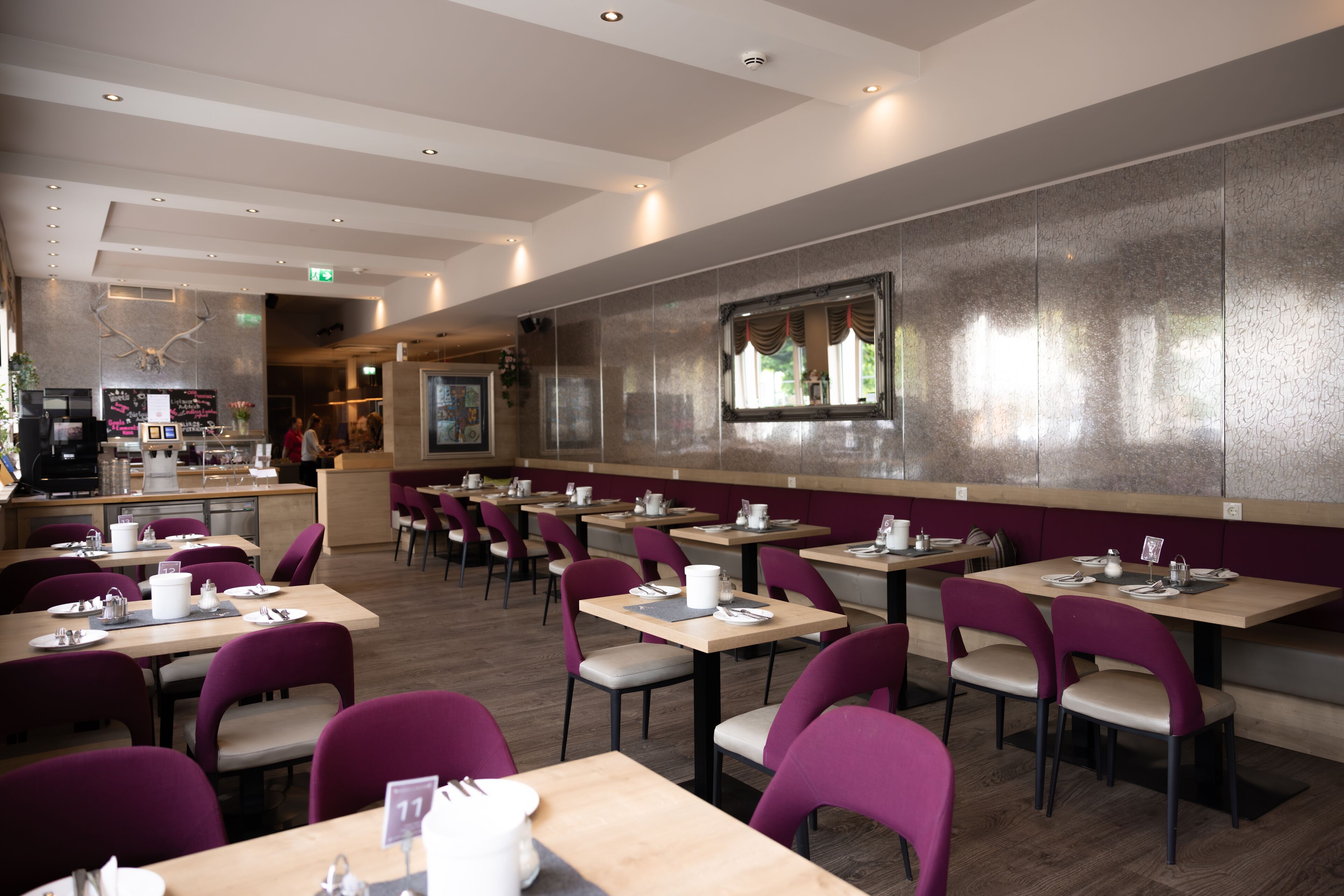 A restaurant with multiple tables and chairs, a bar area, and a counter.