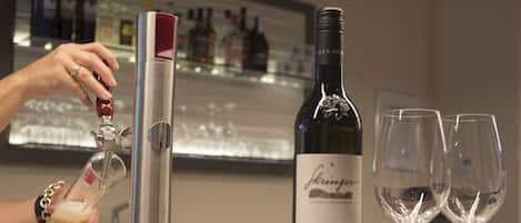 A bar area with a wine bottle labeled "Schirner Sauvignon Blanc 2017" and two empty wine glasses.