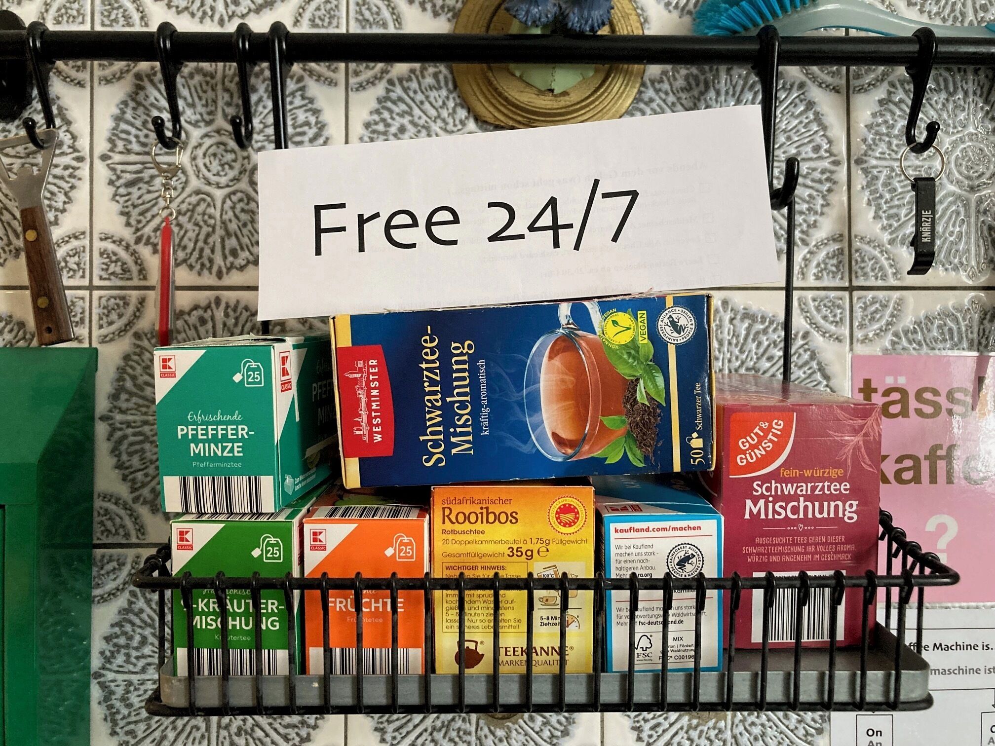 A shelf with various packaged food items, including a sign indicating 'Free 24/7'.