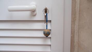 Una puerta blanca con una llave y un llavero azul.