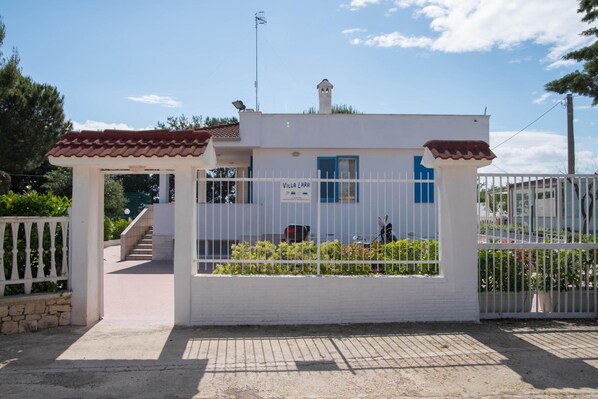 Un edificio blanco con una puerta azul y un letrero que dice 'Villa Lara'.