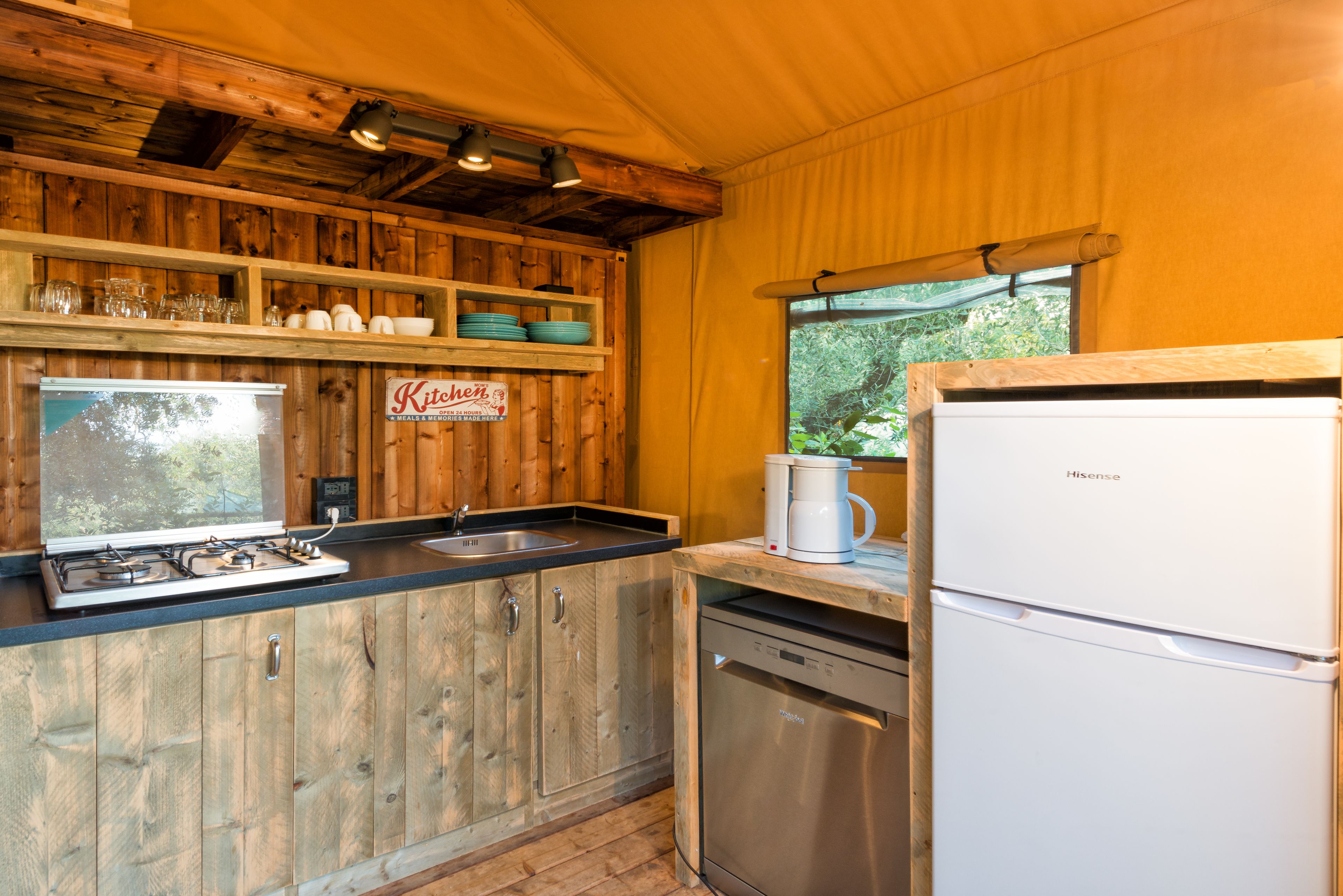 Eine Küche mit Holzschränken, einem Herd, einem Spülbecken und einem Kühlschrank.