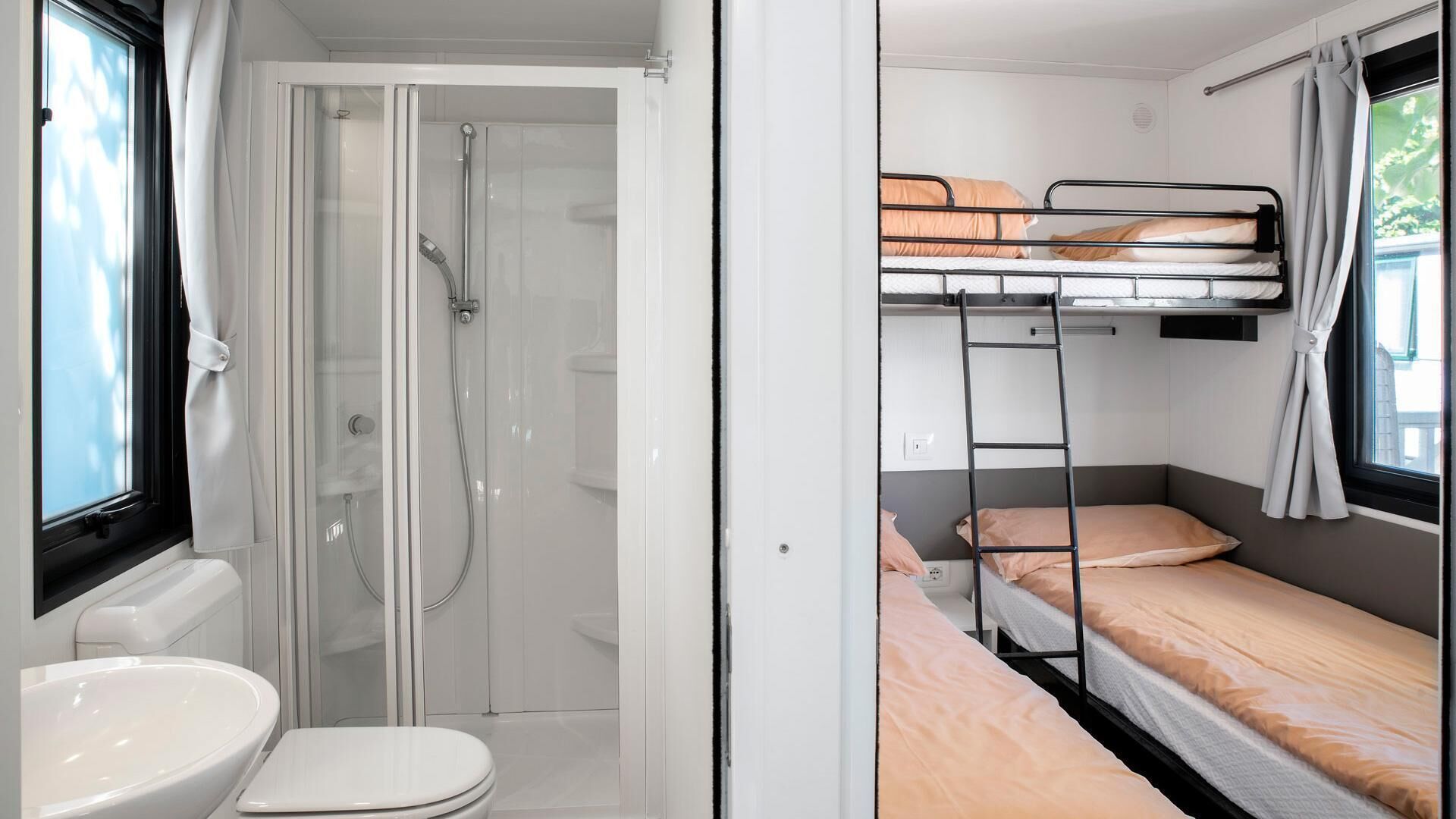 Ein kleines Zimmer mit Dusche, Toilette und Etagenbetten.