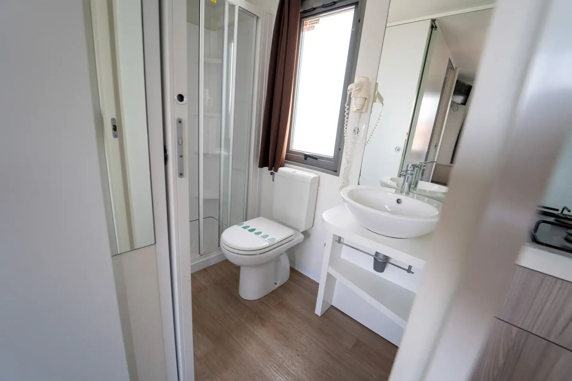 Un baño moderno con inodoro, lavamanos y cabina de ducha.