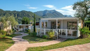 Una casa vacacional moderna con un camino pavimentado que lleva a un porche cubierto.