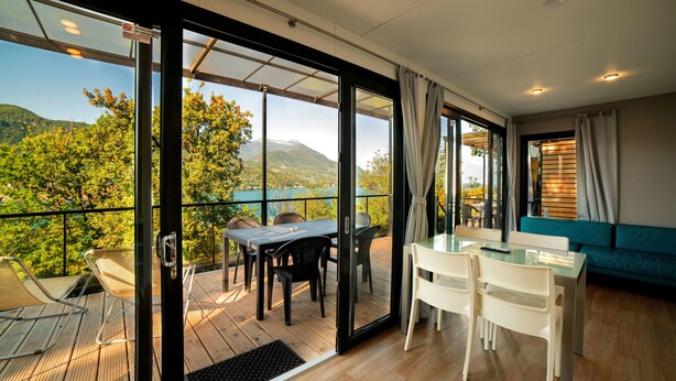 Una habitación moderna con balcón, zona de comedor y sofá.