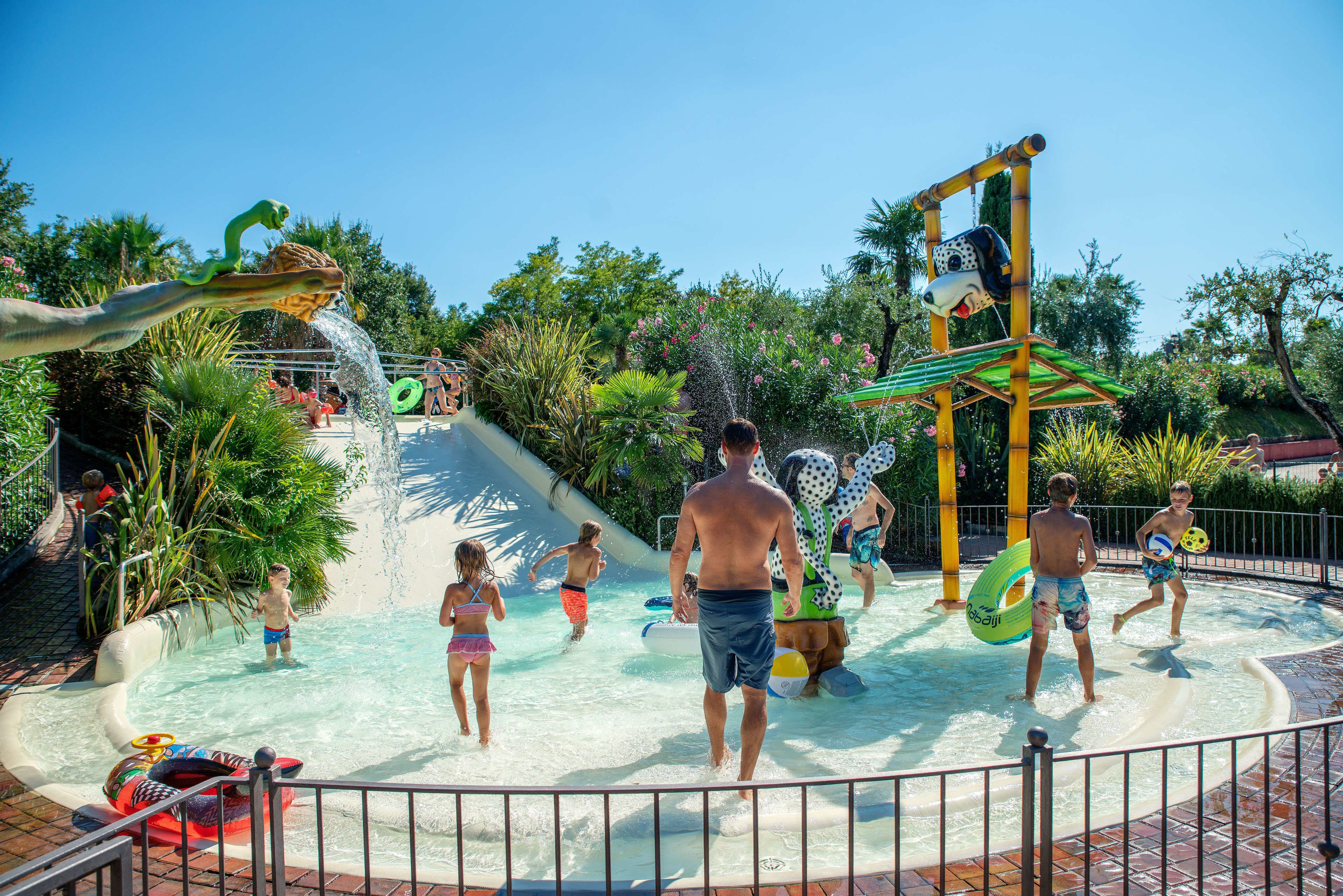 Un parque acuático con piscina, toboganes y diversas estructuras de juego.