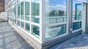 A modern building with large glass windows and a wooden deck. - Heaven on Midtown Fully Furnished Apts (Atlanta)