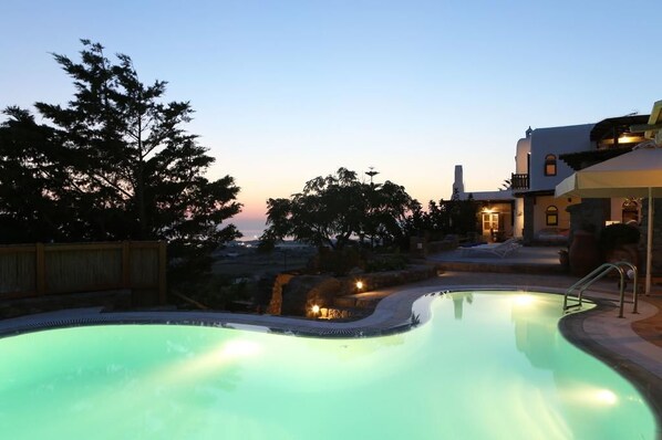 Een buitenzwembad, parasols voor strand/zwembad