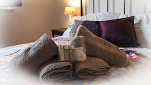 A neatly made bed with folded towels, a set of toiletries, and a lamp in the background. - Stunning Central Richmond with garden (Richmond)