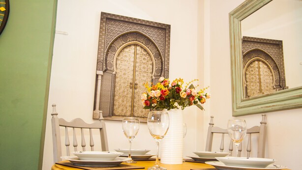 A dining table with plates, glasses, and a vase of flowers. - Stunning Central Richmond with garden (Richmond)
