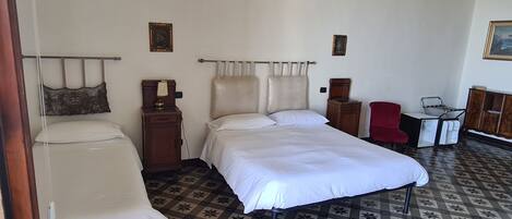 A room with a bed, a chair, a small table, and a cabinet.