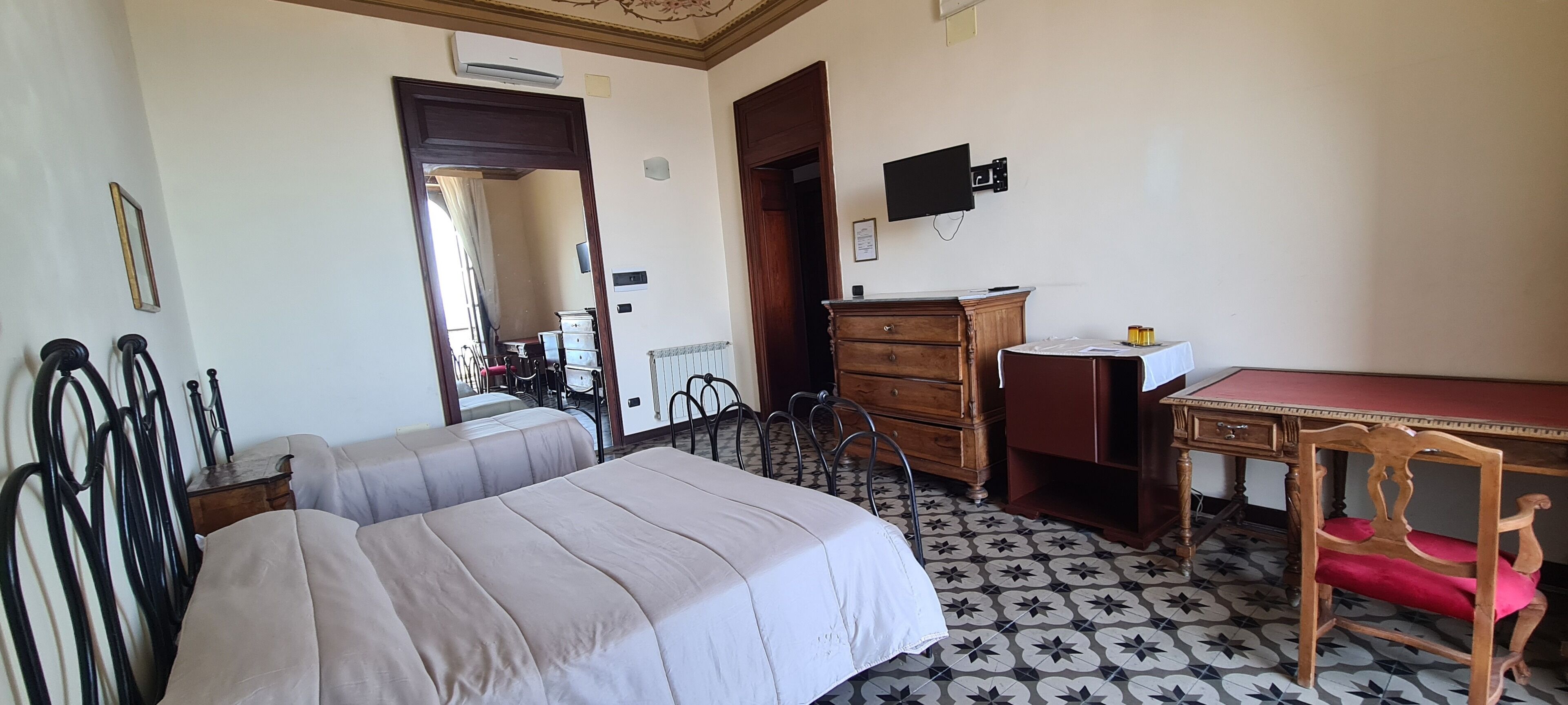 Una camera da letto con un letto, una scrivania, una cassettiera e una sedia.