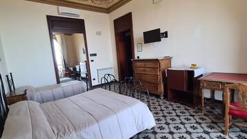 Una camera da letto con un letto, una scrivania, una cassettiera e una sedia.