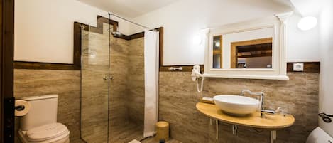 Une salle de bain moderne avec une douche à parois de verre, des toilettes et un lavabo avec un miroir au-dessus.