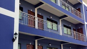 A multi-story building with balconies, wooden doors, and potted plants. - Nan Green View Hotel (Nan)