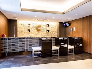 Un espace d’accueil moderne avec un mur en pierre, une décoration en forme de croissant de lune et un téléviseur à écran plat.