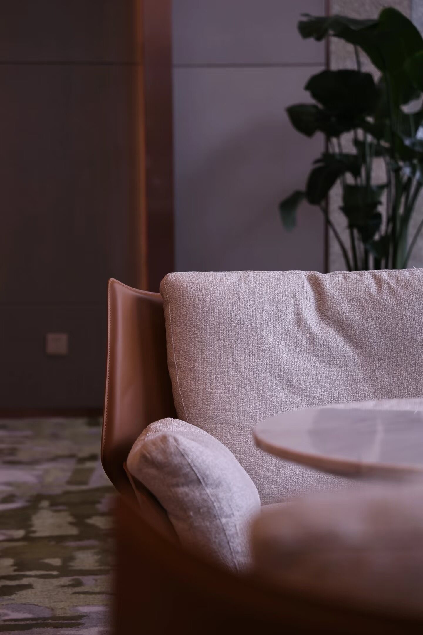 Un salon moderne avec un canapé, une petite table ronde et une plante en pot.