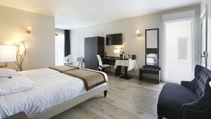 Une chambre d’hôtel avec un lit, un bureau, une chaise et un grand miroir.