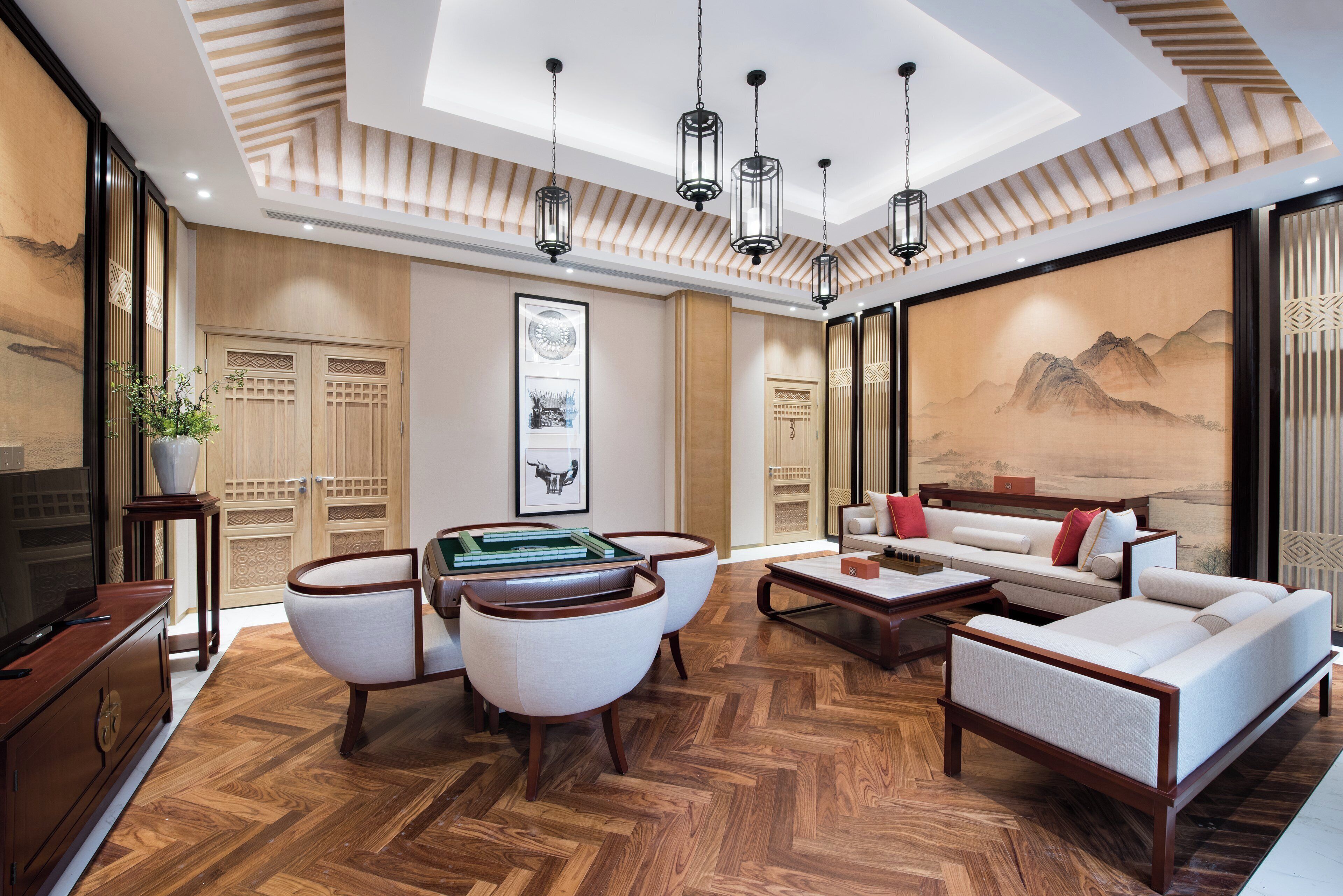 A traditional-style living room with a herringbone wood floor, a sofa set, a coffee table, and a television.