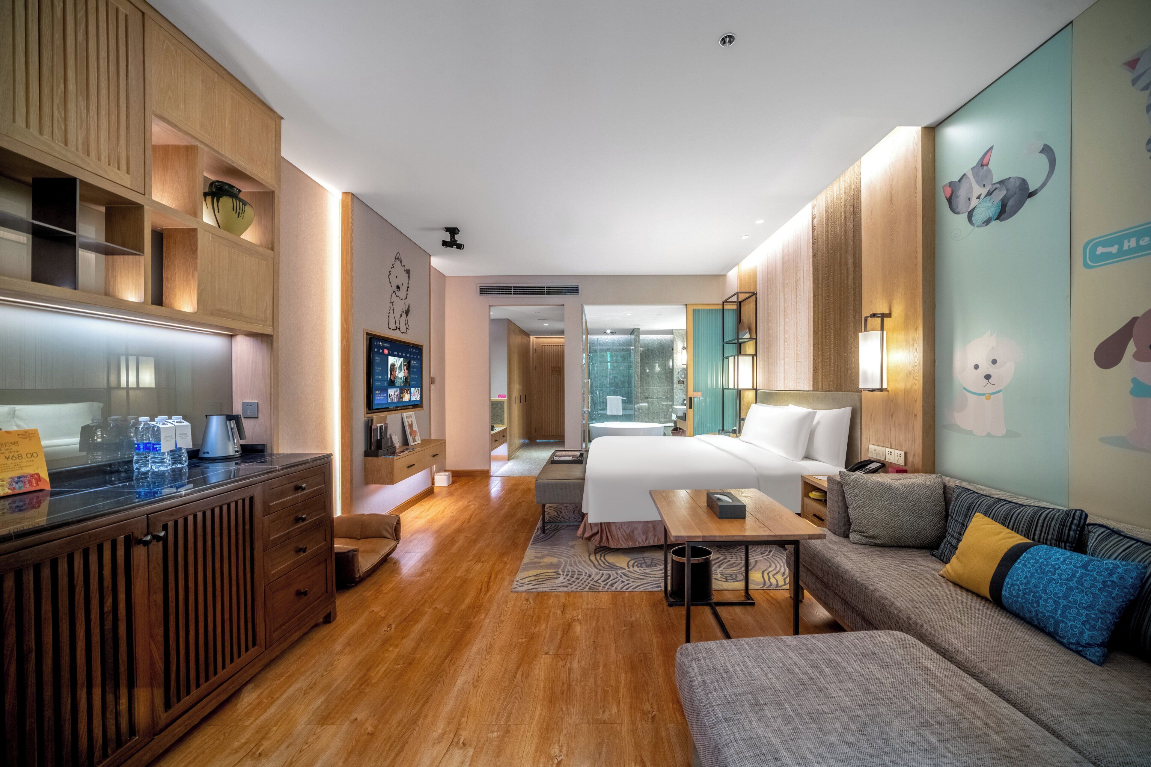 Una habitación de hotel moderna con un armario de madera, una cama, un sofá y un escritorio.