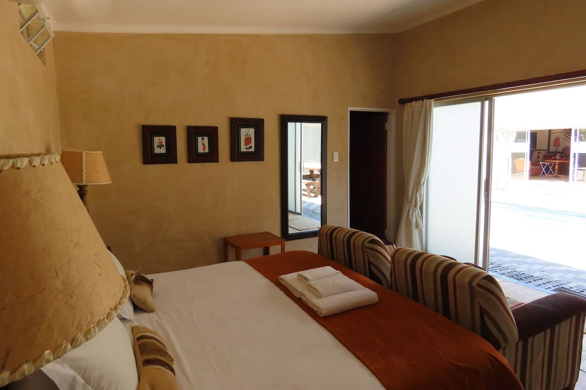 Une chambre d’hôtel avec un lit, un bureau, une chaise et une vue sur l’extérieur.