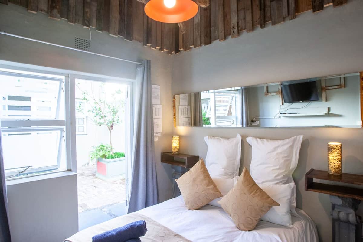 Ein Schlafzimmer mit einem Bett, einem Fernseher und einem Fenster mit Blick nach draußen.