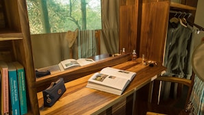 Een houten wastafelmeubel met spiegel, boeken, een handtas en toiletartikelen.