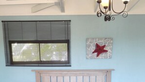Une chambre à coucher avec un lit, un banc en bois, un lustre et une étoile décorative sur le mur.