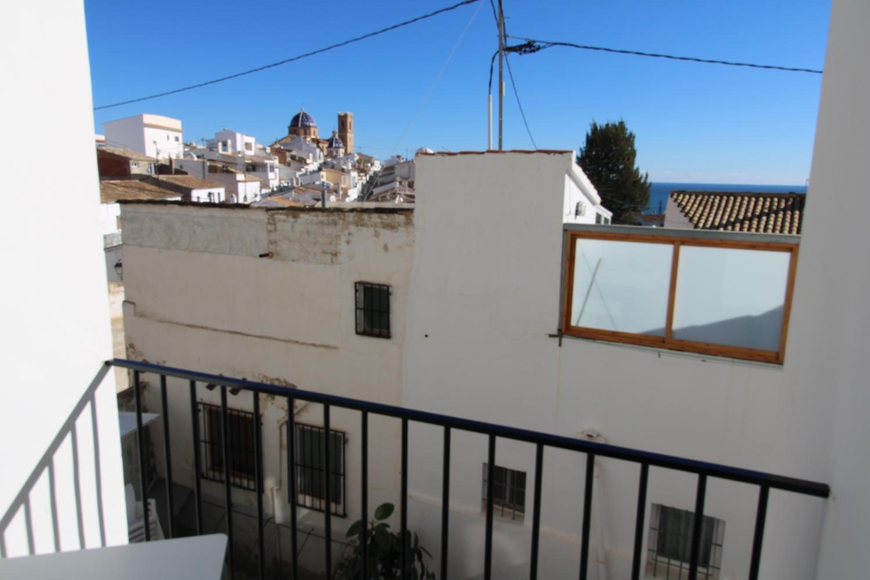 A white building with a balcony and a window.